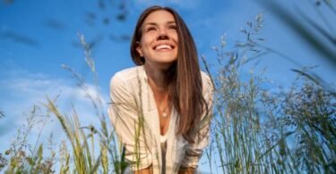 Low angle view portrait of a woman standing in the meadow Healthy Ways to Spend Your Free Time